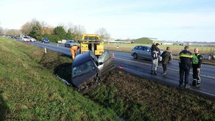 Modder op de weg, auto in de greppel